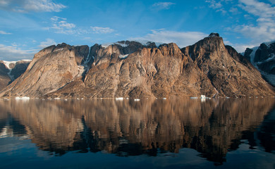 Fototapeta na wymiar Mountains and icebergs reflected in calm water, O Fjord, Greenland