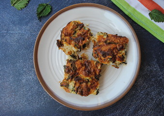 Three slices of Nettle pie with cheese in a beige retro plate, on a black background. Delicious spring pie.