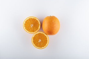 ripe oranges with sliced halves close-up on a white background
