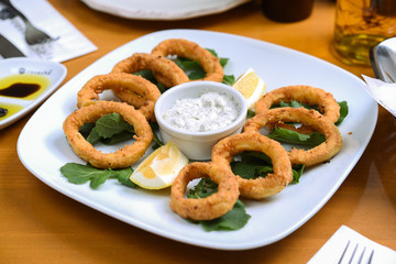 snack onion rings and sauce on pieces of greens