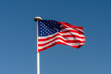 The starry flag of the United States of America (USA) on the blue sky background