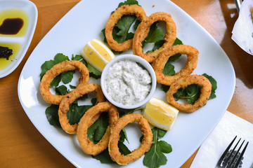 snack onion rings and sauce on pieces of greens