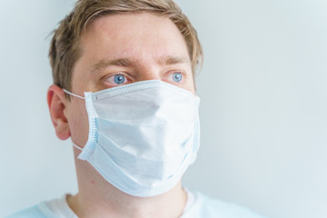 Doctor in blue medical robe,disposable face mask.Hero tired from work, in despair from treatment of sick patients in hospital. Fighting with coronavirus covid-19.World pandemic of dangerous infection