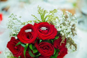 There are drops of water on the roses . Wedding bouquet of red flowers.