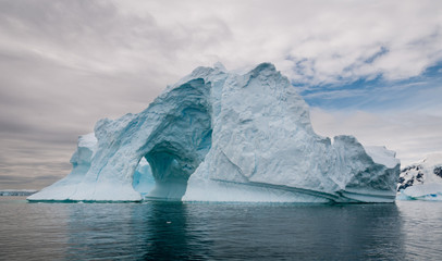 Fototapeta na wymiar Arched and weathered iceberg, Antarctic Peninsula