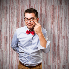 Man wearing a red bow tie. Pointing to his eye.