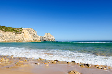 Fototapeta na wymiar View of the limestone cliffs and Atlantic ocean. Ravine Beach (Praia do Barranco) - wild beach and popular surfing spot in Algarve. Sagres (Vila do Bispo), District Faro, Southern Portugal.