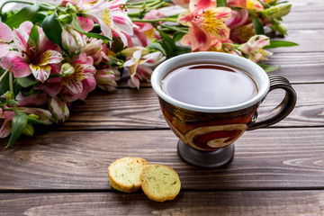 
cup of tea on the table. flowers, tea cookies.