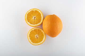 ripe oranges with sliced halves close-up on a white background