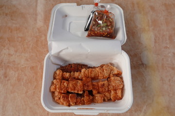 traditional Thai culture air fryer fried pork cuisine style or moo tod krob favorite famous street fast foods menu at thailand homemade
with hot spicy sauces on table wood dish sticky rice vegetable