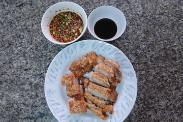 traditional Thai culture air fryer fried pork cuisine style or moo tod krob favorite famous street fast foods menu at thailand homemade
with hot spicy sauces on table wood dish sticky rice vegetable