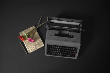 Still life of writing with typewriter, flowers, notebook and fountain pen