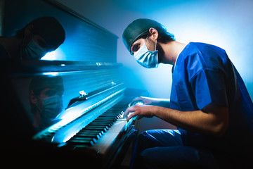 Medico pianista si rilassa suonando il pianoforte dopo il turno in ospedale - obrazy, fototapety, plakaty