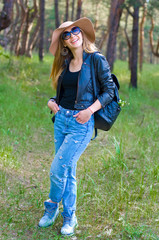 vertical portrait of a young cheerful long-haired girl on a background of nature