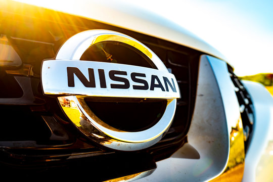SURREY, UK- MAY, 2020: Nissan logo on front grill of white Nissan Juke with warm soft tones 
