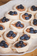 Closeup of delicious creamy brownie nests with fresh organic blueberry. A delicious dessert or snack.