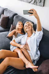 Mom and daughter take a selfie on vacation and smile at the camera