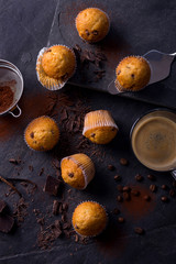 Plain mini muffins with chocolate chips on dark grey stone
