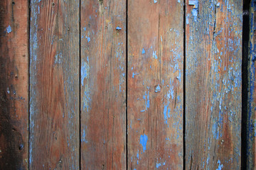 background of dark brown planks and remnants of blue paint
