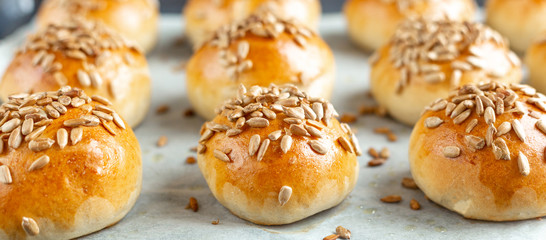 Hot fresh homemade buns sprinkled with seeds. Close-up, selective focus