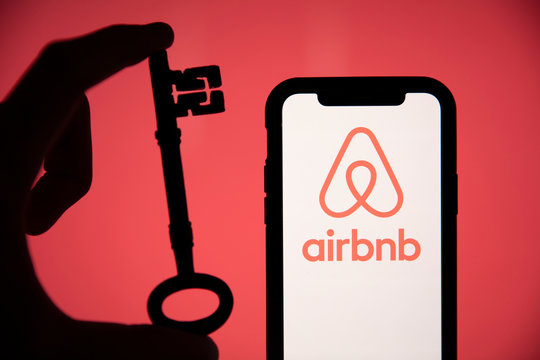 LONDON, UK - May 15 2020: Airbnb Home Rental Logo On A Phone With A Key