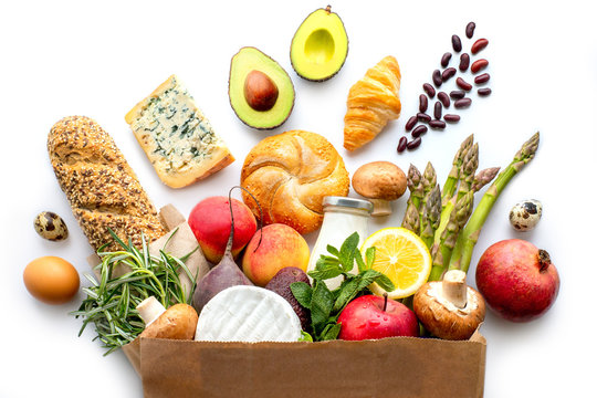 Paper bag with healthy food. Vegetarian food. Healthy food background. Supermarket food concept. Asparagus, cheese, milk, fruits, vegetables, avocados and mushrooms. Shopping at the supermarket. 