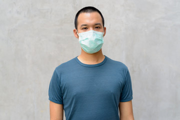 Young Asian man with mask for protection from corona virus outbreak outdoors