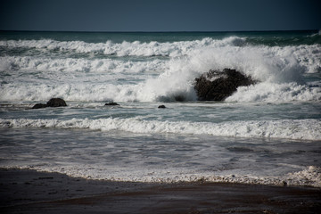Una ola rompe contra la roca