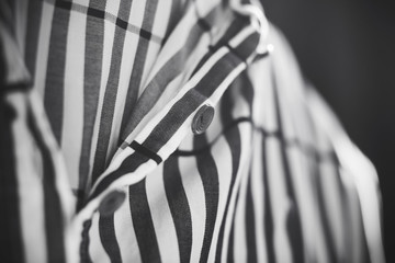 Black and white image of a striped loose soft cotton shirt buttoned up.