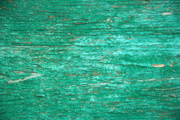 background old wooden board covered with green paint in the cracks