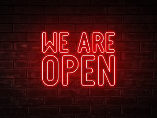 We are open - red neon light word on brick wall background	