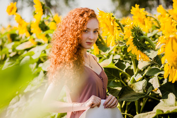 Red hair girl in sunflowers