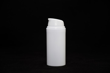white plastic cosmetic bottle on black background