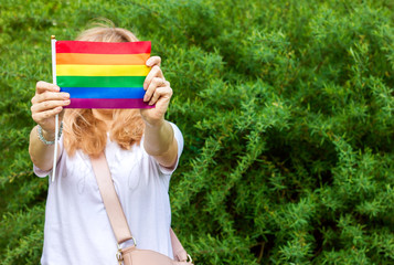  Rainbow LGBT flag in the hands of a girl, concept of gender equality. Lesbian and gay...