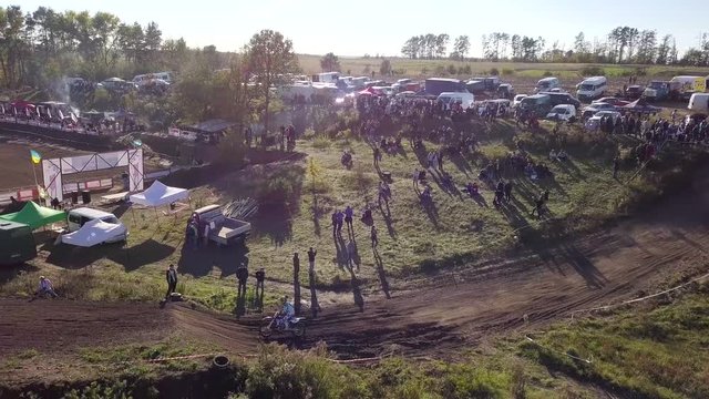 People stand on the hills and watch a motocross race