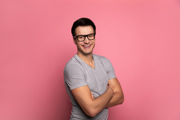 A creative director.Close-up photo of a cheerful man in glasses, who is looking in the camera, while standing in semi-profile with folded arms.