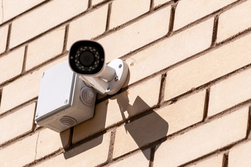 videcam mounted on a brick wall of a house on a summer day