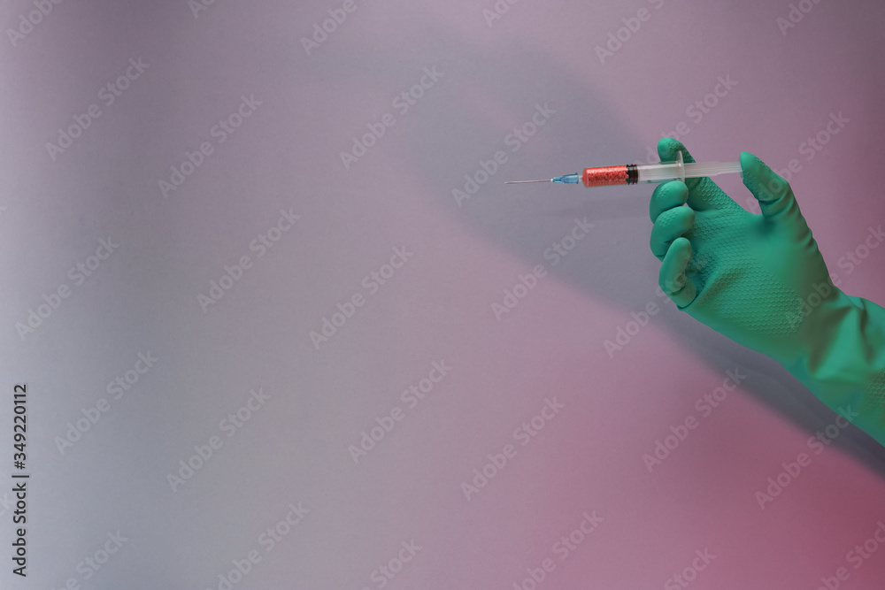 Poster Beautiful hand holding creative syringe with red vaccine in the neon light. Minimalism retro style concept. Background pattern for design...