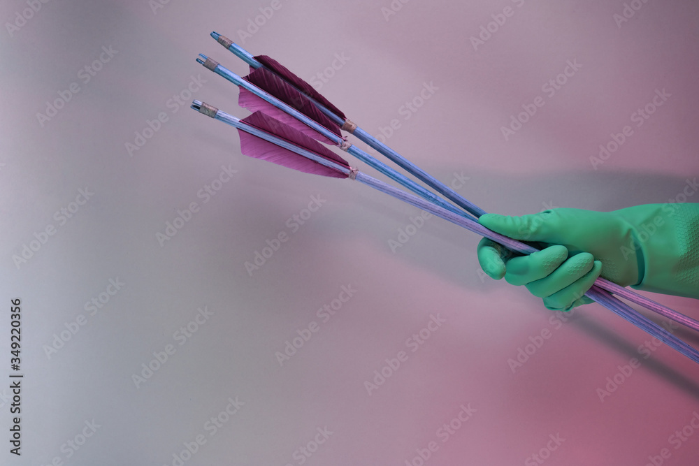 Aufkleber Beautiful hand holding old green arrows in the color light. Beautiful old arrow minimal in neon light. Minimalism retro style concept. Background pattern for design..