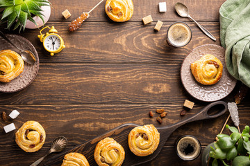 Food background with fresh pastry sweet swirl buns with raisins for breakfast or brunch and coffee. Top view, copy space.