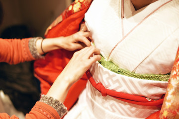 A Japanese woman dressing a traditional wedding kimono.