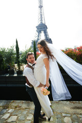 Obraz premium Bride and groom having a romantic moment on their wedding day in Paris, in front of the Eiffel tour