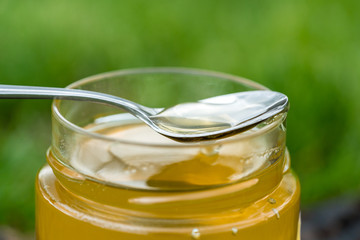 A spoon and a jar full of delicious honey