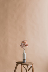 Artificial flowers in a vase. Studio photography of flowers. Decorative flowers with own hands. A minimalist bouquet of artificial flowers 