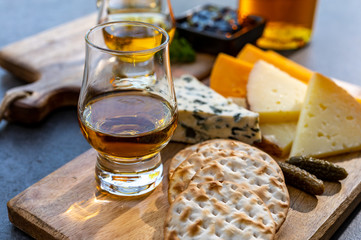 Whiskey and cheese pairing, tasting whisky glasses and plate with sliced cheeses
