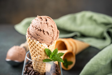 Delicious coffee or chocolate ice cream in waffle cone for dessert. Summer healthy food concept, lactose free.