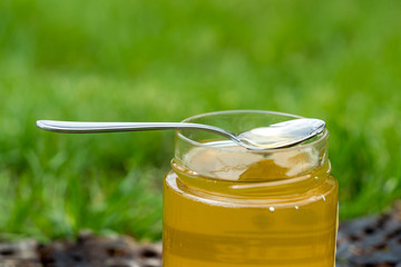 A spoon and a jar full of delicious honey