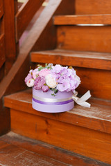 Artificial flowers. Decorative flowers in a round box. Flowers in purple. 