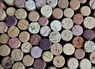 blurred background of used wine corks in pink and purple colors