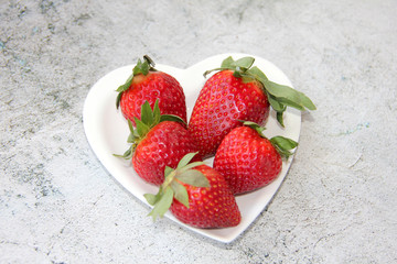 strawberries on a plate in the shape of a heart